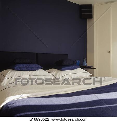 Blue and white pillows on bed against dark blue wall View Large Photo Image Stock Image - Blue and white pillows on bed against dark blue wall. Fotosearch