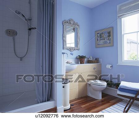 Stock Photograph - Blue curtain on shower cabinet in blue traditional bathroom. Fotosearch