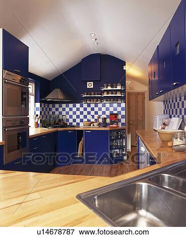 Blue fitted units in modern kitchen with blue+white wall tiles View Large Photo Image Stock Photo - Blue fitted units in modern kitchen with blue+white wall tiles. Fotosearch
