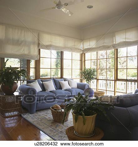 Blue sofa in front of French windows with white blinds in modern living room extension View Large Photo Image Stock Image - Blue sofa in front of French windows with white blinds in modern living room extension. Fotosearch