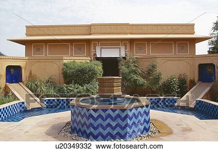 Stock Image - Blue tiled fountain and pool in courtyard of sandstone Rajvilas hotel in Rajastan. Fotosearch