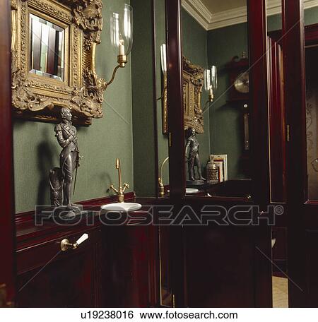 Bronze statue on shelf above small corner basin in green cloakroom with mahogany panelling View Large Photo Image Stock Photograph - Bronze statue on shelf above small corner basin in green cloakroom with mahogany panelling. Fotosearch