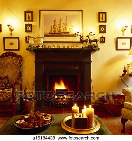Candles On Table In Front Of Fireplace With Lighted Fire In Yellow