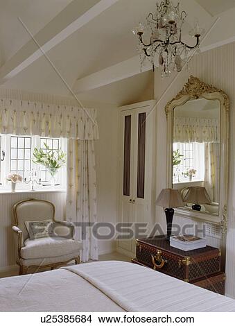 Chandelier in cream country bedroom with large mirror View Large Photo Image Picture - Chandelier in cream country bedroom with large mirror. Fotosearch