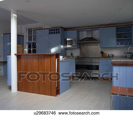Cherrywood unit in modern kitchen with blue fitted units and limestone flooring View Large Photo Image Stock Photograph - Cherrywood unit in modern kitchen with blue fitted units and limestone flooring. Fotosearch