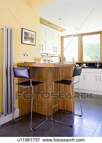 Chrome And Black Leather Stools At Breakfast Bar In Modern Yellow