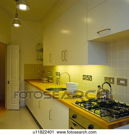 Chrome kettle on hob in modern kitchen with green tiled splash-back View Large Photo Image Stock Image - Chrome kettle on hob in modern kitchen with green tiled splash-back. Fotosearch