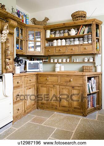 Stock Photograph - Citted pine cupboards and units in country kitchen. Fotosearch