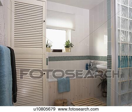 Stock Photo - Class brick wall in small modern tiled bathroom. Fotosearch