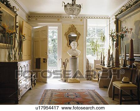 Stock Photo - Classical bust on plinth in large country hall with antique furniture. Fotosearch