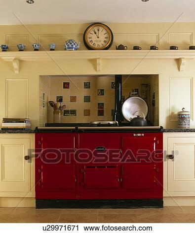 Clock on shelf above red Aga oven in cream townhouse kitchen View Large Photo Image Stock Image - Clock on shelf above red Aga oven in cream townhouse kitchen. Fotosearch