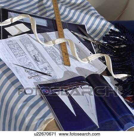 Stock Image - Close-ip of old wooden ruler with magazine showing sailing ship and drawings. Fotosearch