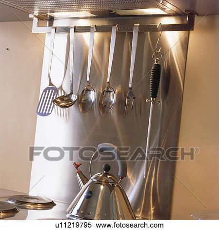 Close-up of Alessi kettle below stainless-steel rack with steel kitchen utensils View Large Photo Image Stock Photography - Close-up of Alessi kettle below stainless-steel rack with steel kitchen utensils. Fotosearch