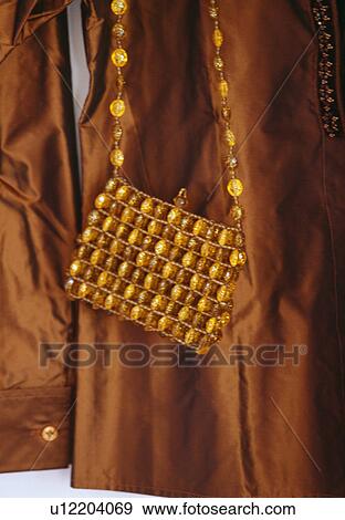 Close-up of amber-beaded handbag on brown silk jacket View Large Photo Image Stock Photo - Close-up of amber-beaded handbag on brown silk jacket. Fotosearch