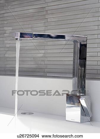 Close-up of angular chrome tap pouring water into sink View Large Photo Image Picture - Close-up of angular chrome tap pouring water into sink. Fotosearch