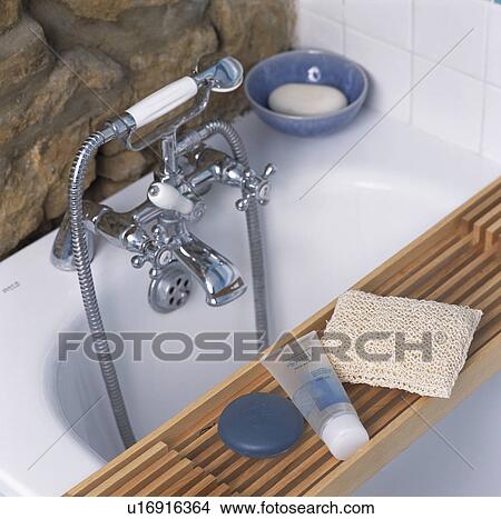 Picture - Close-up of bath taps and shower-head with wooden bath rack. Fotosearch