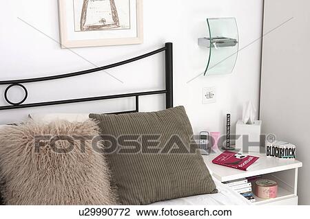 Close-up of beige faux fur cushion and brown cushion on metal bed in white bedroom View Large Photo Image Stock Image - Close-up of beige faux fur cushion and brown cushion on metal bed in white bedroom. Fotosearch