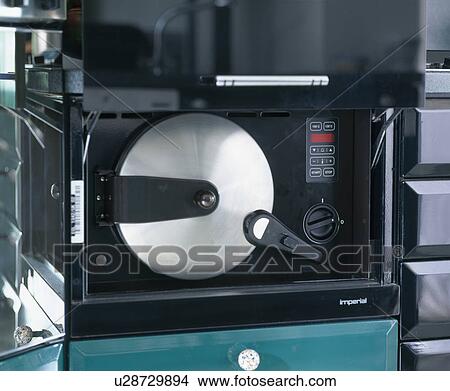 Picture - Close-up of black and metal oven door. Fotosearch