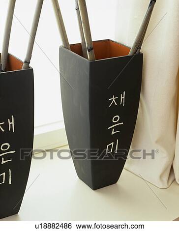 Stock Photograph - Close-up of black angular vases with oriental writing. Fotosearch