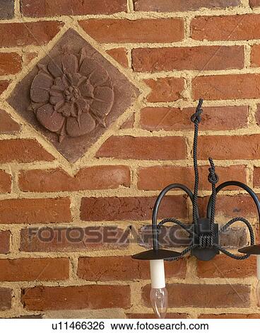 Close-up of black cast-iron wall-light on brick wall with decorative terracotta tile View Large Photo Image Stock Photograph - Close-up of black cast-iron wall-light on brick wall with decorative terracotta tile. Fotosearch