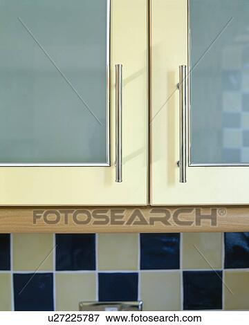 Stock Photo - Close-up of blue fitted kitchen cupboard with steel handles. Fotosearch