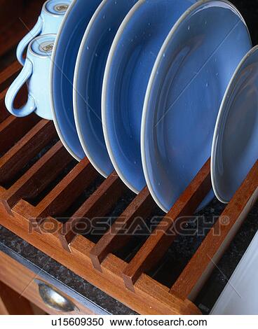 Stock Image - Close-up of blue plates on wooden rack. Fotosearch
