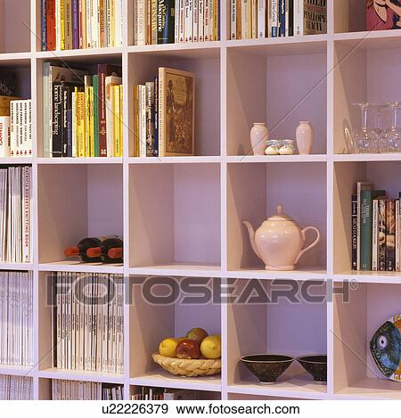 Stock Photo - Close-up of books and teapot on modern cube shelving. Fotosearch