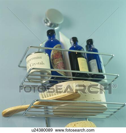 Stock Photo - Close-up of bottles of bath oils and brush on metal storage rack. Fotosearch