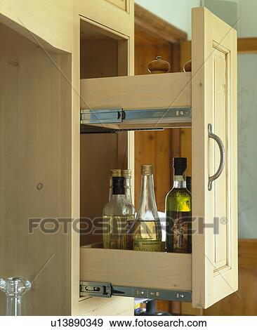 Stock Photo - Close-up of bottles of oil stored on pull-out shelves . Fotosearch