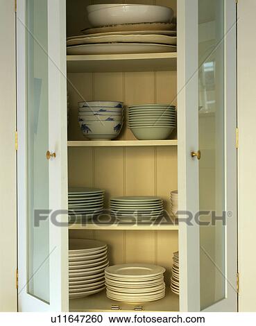 Close-up of bowls on shelves in kitchen cupboard with open doors View Large Photo Image Stock Image - Close-up of bowls on shelves in kitchen cupboard with open doors. Fotosearch
