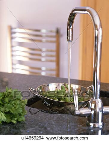 Close-up of chrome mixer tap pouring water into stainless steel colander View Large Photo Image Picture - Close-up of chrome mixer tap pouring water into stainless steel colander. Fotosearch