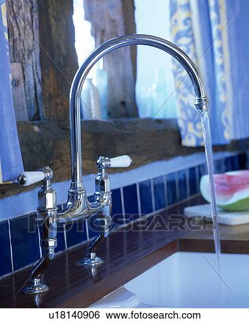 Close-up of chrome mixer tap pouring water into sink View Large Photo Image Stock Photograph - Close-up of chrome mixer tap pouring water into sink. Fotosearch