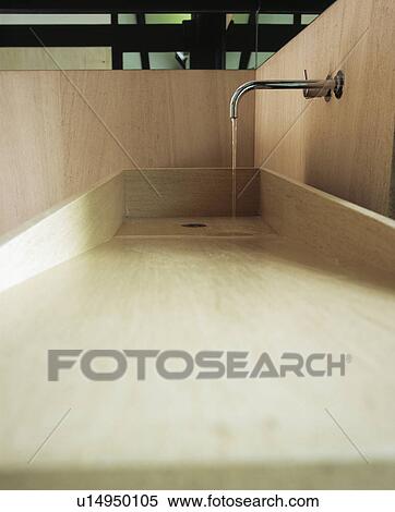 Stock Photography - Close-up of chrome tap and wooden basin. Fotosearch