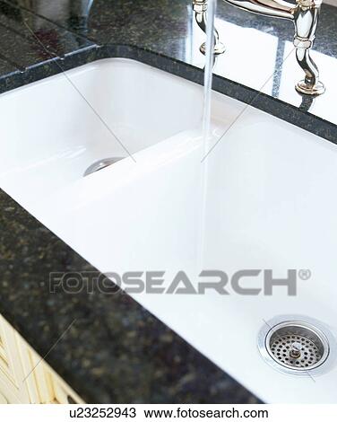 Close-up of chrome tap pouring water into underset double white ceramic sink View Large Photo Image Stock Image - Close-up of chrome tap pouring water into underset double white ceramic sink. Fotosearch