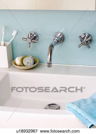 Close-up of chrome taps and glass splashback above modern rectangular basin View Large Photo Image Stock Photo - Close-up of chrome taps and glass splashback above modern rectangular basin. Fotosearch