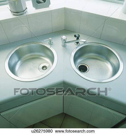Stock Image - Close-up of circular double stainless steel sinks. Fotosearch