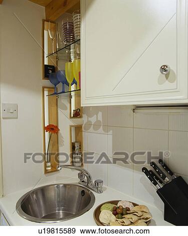 Stock Photo - Close-up of circular stainless steel sink below shelving. Fotosearch