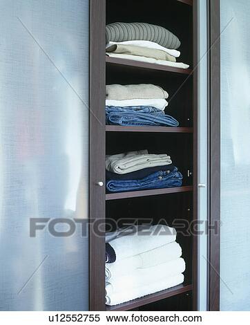 Close-up of clothes and towels on storage shelves in wardrobe View Large Photo Image Stock Photography - Close-up of clothes and towels on storage shelves in wardrobe. Fotosearch