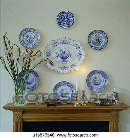 Stock Photo - Close-up of collection of antique blue+white china displayed on wall above mantelpiece. Fotosearch