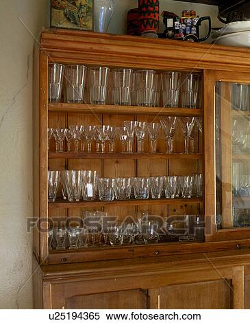 Stock Photography - Close-up of collection of glasses on wooden shelves. Fotosearch