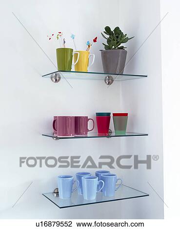 Stock Image - Close-up of colourful cups on glass shelves. Fotosearch