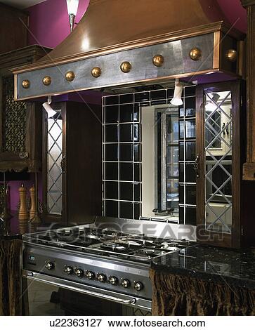 Close-up of copper extractor above oven with mirror tile splashback View Large Photo Image Stock Photo - Close-up of copper extractor above oven with mirror tile splashback. Fotosearch
