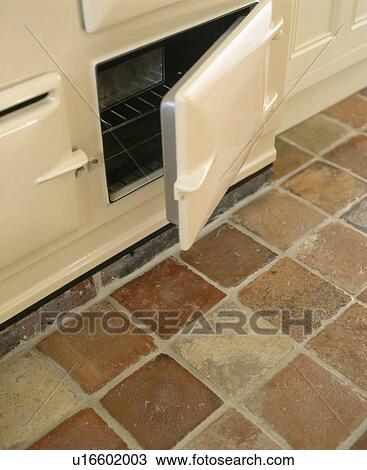 Close-up of cream Aga oven with open door above terracotta floor tiles View Large Photo Image Stock Image - Close-up of cream Aga oven with open door above terracotta floor tiles. Fotosearch