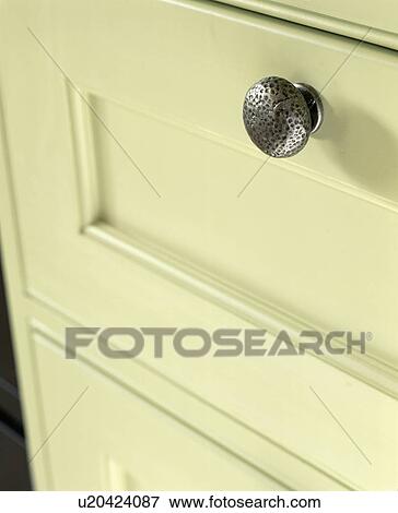 Stock Photo - Close-up of cream kitchen drawer with brushed pewter handle. Fotosearch