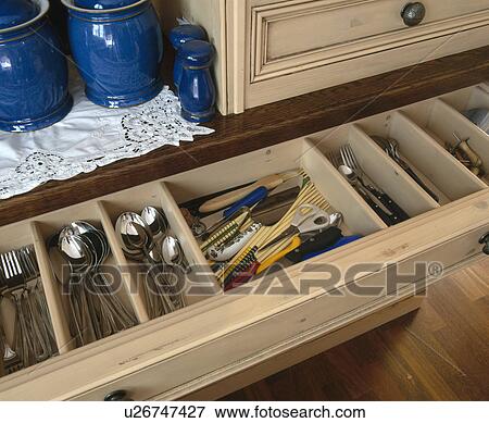 Stock Photo - Close-up of cutlery in wooden storage drawer. Fotosearch