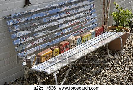 Stock Photograph - close-up of dilapidated Victorian bench with colourfully painted bricks. Fotosearch