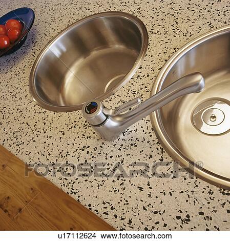 Picture - Close-up of double stainless steel circular sinks in granite worktop. Fotosearch