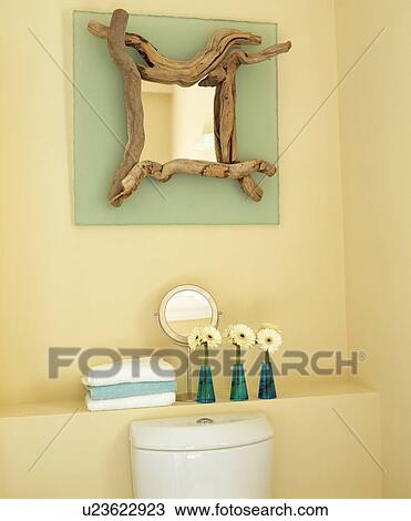 Stock Image - Close-up of driftwood mirror above shelf. Fotosearch