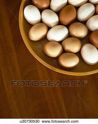 Stock Image - Close-up of eggs in wooden bowl. Fotosearch
