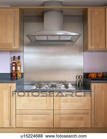 Stock Photo - Close-up of extractor above hob in fitted wooden unit in modern kitchen. Fotosearch